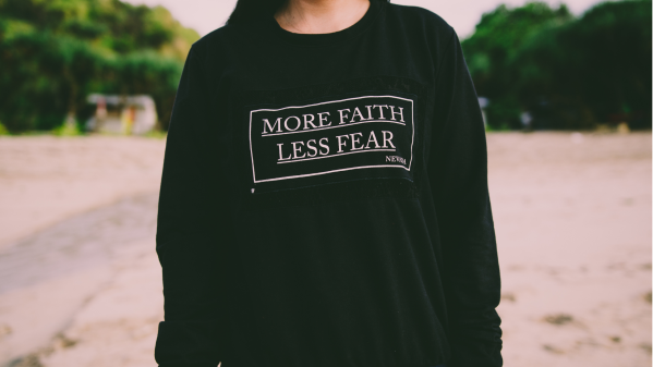 Girl wearing more faith less fear shirt